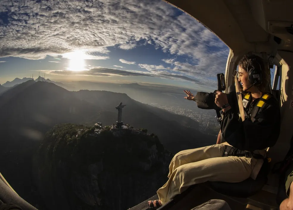 Passageira em helicóptero sem portas sobre o Cristo Redentor